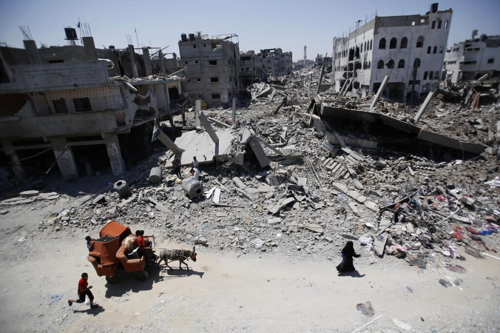 palestinians carry their belongings through the heavily bombed gaza city
